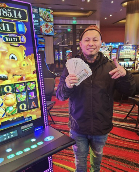 man with cash jackpot at slot machine in legends bay casino