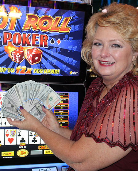 woman holding cash jackpot from video poker at Legends Bay Casino