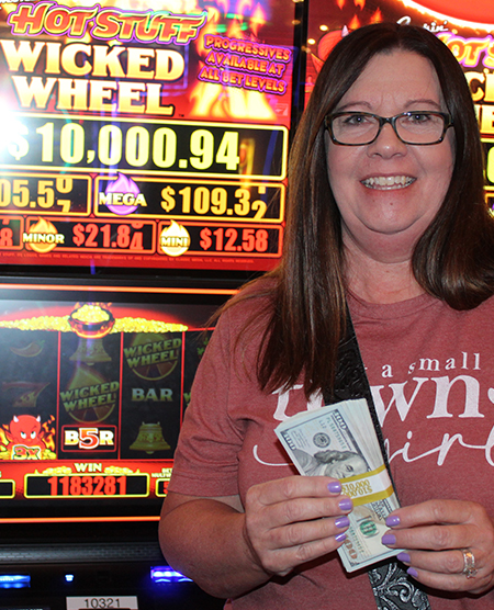 woman holding cash jackpot from slots at Legends Bay Casino