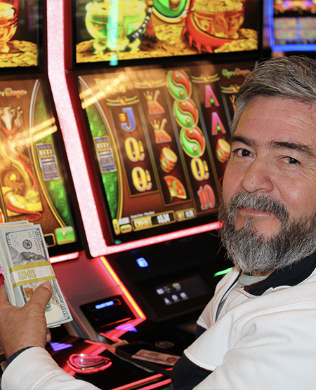 man holding a slots jackpot at legends bay casino